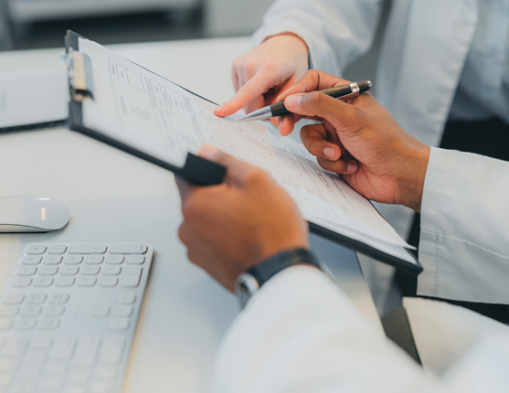 Image: Close in shot of doctor's hands holding and reviewing documents