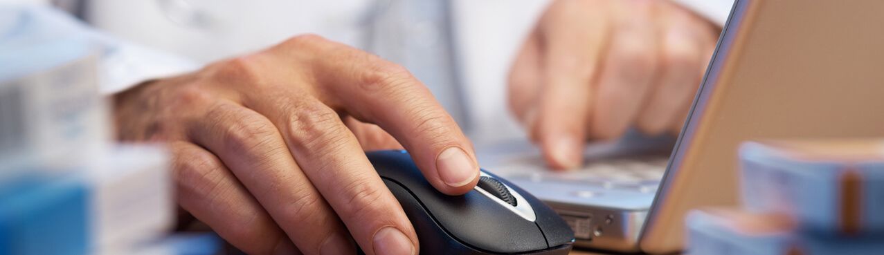 hands clicking a mouse, working on computer