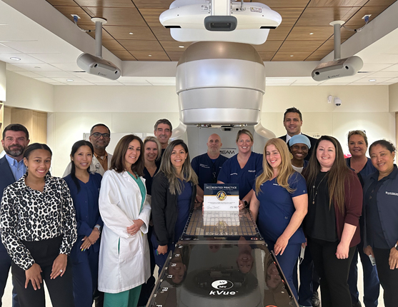 Image: Radiation Oncology staff standing in front of linac machine at the Miami Cancer Institute