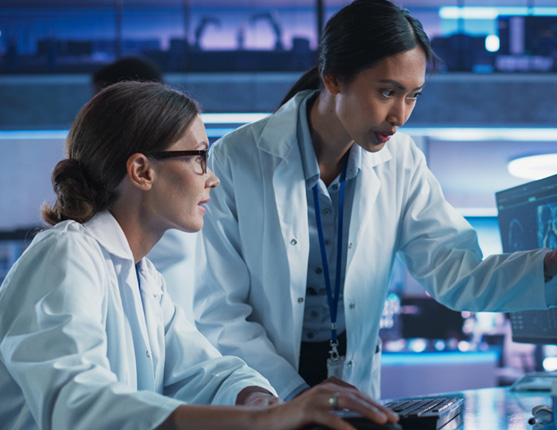 Image: Two female scientists collaboratively working at computers