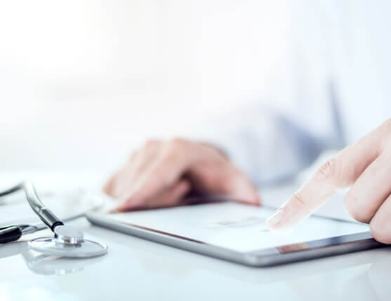 Image: Doctor reading on a tablet at desk