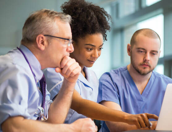 Image: 3 Doctors looking at a laptop