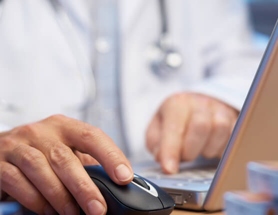 Image: hand on mouse by laptop
