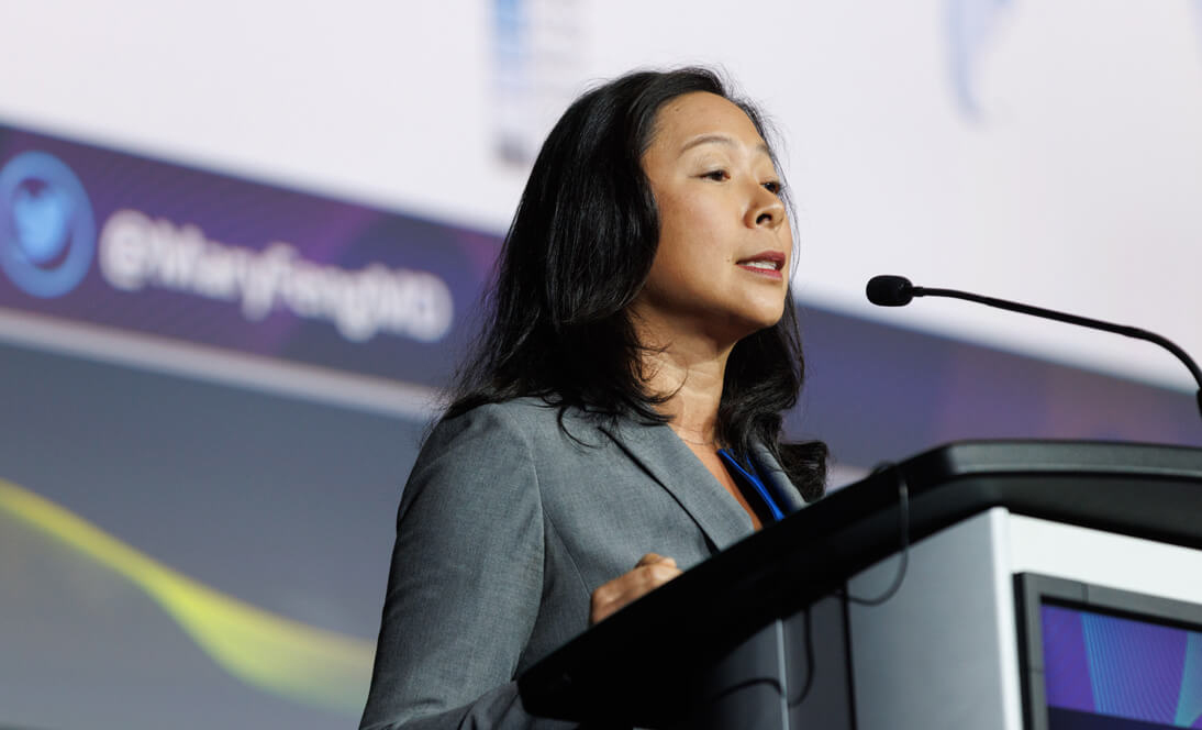 Image: woman at podium presenting science at meeting