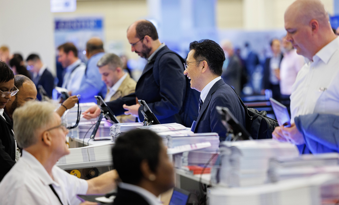 Image: People at registration desk at meeting